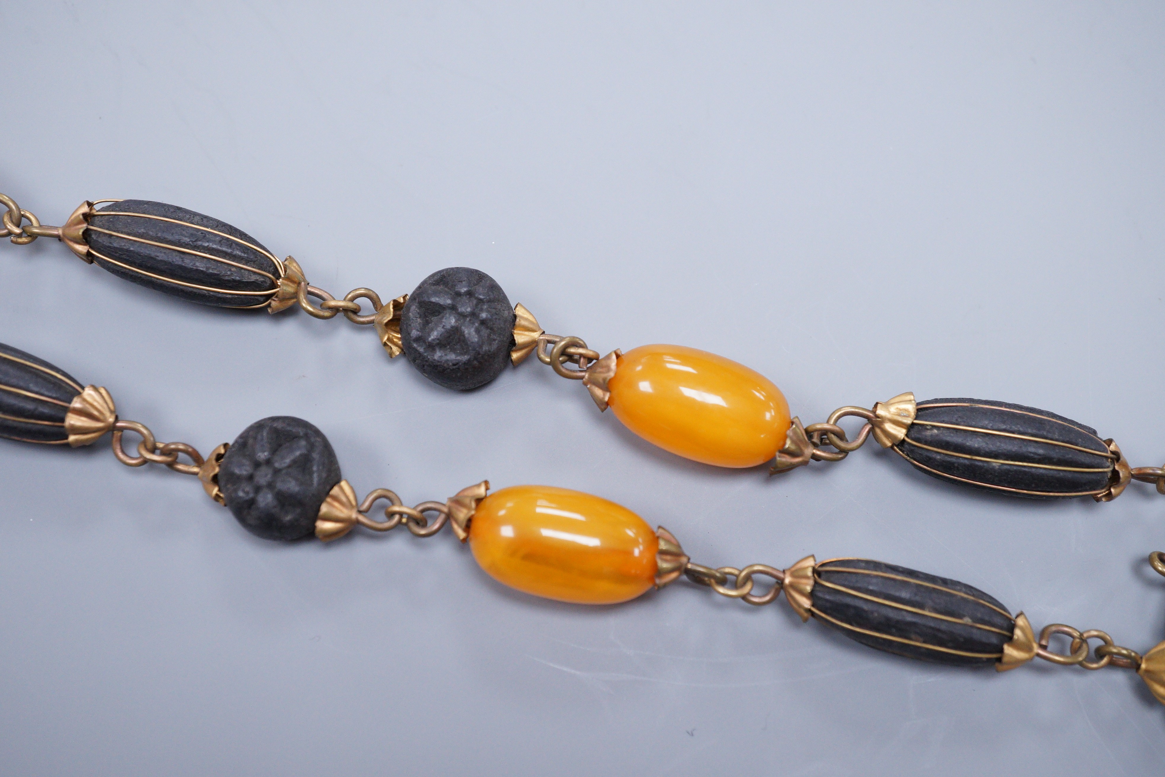 A 1930's gilt brass mounted composition and simulated amber bead necklace, 40cm